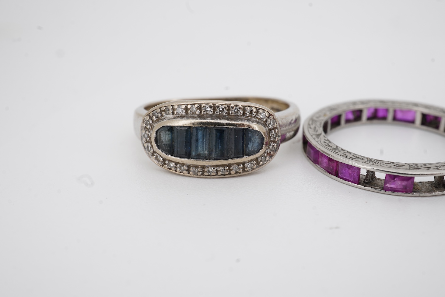 A yellow metal and illusion set three stone diamond crossover ring, size I, an 18ct, sapphire and diamond chip set ring, a modern 18ct gold and six stone sapphire set ring, with diamond chip border and an engraved white